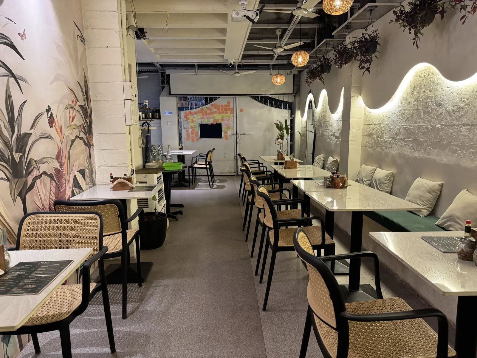 Botanical mural and green bench seating at Cafe Orelo